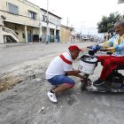 Antonio Cedeño (izq.) ayuda a su padre de 70 años para salir de la tierra en el que cayó,