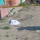 Una de las cabezas de un hombre sobre la esquina de una calle sin asfaltar.