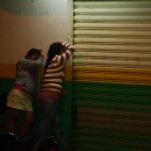 Los familiares del asesinado lloran al pie de la farmacia donde ocurrió el crimen.