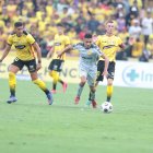 El uruguayo Bruno Piñatares (i) y Damián Díaz (d), argentino nacionalizado ecuatoriano, de Barcelona, pelean el balón con el gaucho Víctor Figueroa (c), de Aucas.