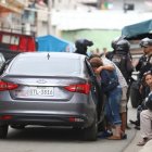 La progenitora del joven llora  al ver el cadáver de su hijo. Familiares la consuelan.