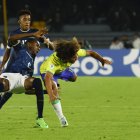 Guilherme Biro (d) de Brasil disputa un balón con Denil Castillo (L) de Ecuador .