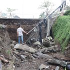 La fuerza del agua provocó que el muro de cemento se viniera abajo. Carros quedaron atrapados.