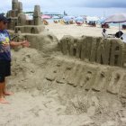 Cristhian Quinde muestra el castillo de arena que fue destruido por los carnavaleros.