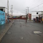 La garita de Ciudad Victoria 2 está ubicada frente a un terreno baldío. El ingreso es controlado por guardias.