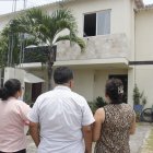 Vecinos observan, consternados, la casa donde el lunes 20 de marzo tres miembros de una familia murieron intoxicados.