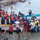 Personas que se encontraban en la orilla se acercaron a la lancha en la que quedaron los cuerpos de los fallecidos.