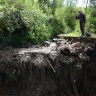 Javier Simbaña muestra la basura y llantas que quedaron luego del desbordamiento.