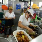 Mientras Ana  Julia sazona el almuerzo, su hija se encarga de contactarse con los clientes por celular.