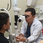 Edwin Villacís, responsable del departamento de Oftalmología del Hospital de Niños Francisco de Icaza Bustamante, revisa los ojos a un paciente escolar.