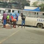 Momento en que un grupo de sujetos se acercó al cuerpo y uno de ellos le sacó objetos de un bolsillo del pantalón.