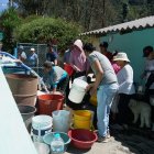 Los vecinos colaboran para abastecerse de agua para los próximos días.