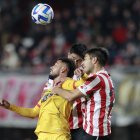 Luciano Lollo (d) y Santiago Núñez (atrás) de Estudiantes disputan el balón con Francisco Fydriszewski (i) de Barcelona.