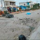 La moto volcada y las dos personas ensangrentadas en la calle.