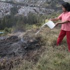 María del Carmen arroja agua para evitar que pequeños focos de humo se expandan.