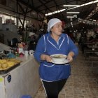 Cristina Delgado lleva un plato de caldo de gallina, también muy solicitado en su negocio.