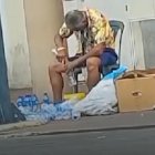 Momento en que El Gato, como es conocido el vendedor de agua, llena con líquido los envases usados.