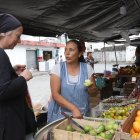 Si es necesario, Doña Nelly hace probar a sus clientes las frutas que ofrece en su puesto.
