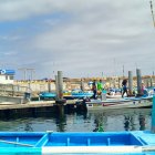 Los familiares de los pescadores se muestran angustiados al pie del muelle.