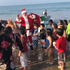 Decenas de niños recibieron a Papá Noel en la orilla de la playa, una vez que llegó en moto acuática.