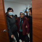 Eva Calva (chompa color vino) sale de la audiencia en contra de Stalyn Caiza, a quien se lo observa en el monitor que está detrás.