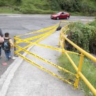 Los peatones deben bajarse a la calle porque el paso está cerrado en la acera.