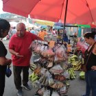 Breston explica a sus clientes lo que pueden usar en sus alimentos cada que llegan a su puesto.