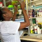 Una comerciante de una farmacia en Quinindé intenta detectar, exponiendo el billete a la contraluz, si este es falso o verdadero.