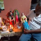 Ante el altar de su casa, Luis Villamar ora y expresa cuán devoto es.