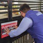 Funcionario de  la Agencia de Aseguramiento de la Calidad de los Servicios de Salud y Medicina Prepagada colocando el sello de clausura en uno de los tres establecimientos