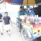 El Chino junto al triciclo que le permite ganarse la vida.