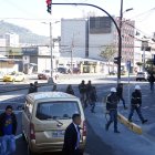 Algunos conductores, pese a la luz roja del semáforo y que peatones están cruzando, avanzan con sus vehículos.