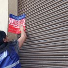 Referencial. Técnicos de la Arcsa clausurando un local comercial.