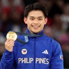 El ganador de la medalla de oro Carlos Edriel Yulo de Filipinas posa en el podio de la final de salto masculino de las competiciones de gimnasia artística en los Juegos Olímpicos de París 2024.