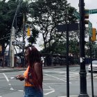 La ciudadana Ashly Cortés, entre el nuevo letrero de ‘República de Guayaquil’ y el antiguo de '10 de agosto'.