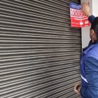 Referencial. Personal de la Arcsa clausurando un local comercial.