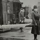 Personal de la Cruz Roja sostiene camillas durante la pandemia de la Gripe Española en 2018.