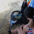 La niña contempla a su bebé en un pequeño coche. Ella le puso los nombres que más le gustaban.