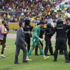 El arquero Víctor Mendoza es protegido por la policía al dirigirse al camerino.
