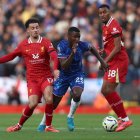 Moisés Caicedo y Curtis Jones disputan el balón.