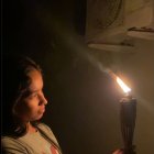 Cindy Vaque enciende las teas y candiles con los que se iluminan en casa.