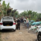 Elementos de la Policía Nacional custodian la escena donde se encontró a la víctima y los autos quemados.
