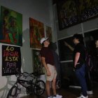 Visitantes tratan de contemplar los cuadros de la galería en la oscuridad.