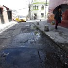 En la calle Villonaco, los vecinos sortean el charco de agua que se forma por la fuga.