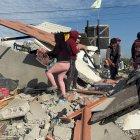 Al amanecer, vecinos y familiares ayudaron a recuperar enseres entre los escombros de la vivienda.