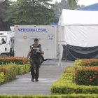 Personal de la Policía Nacional lleva a cabo el traslado de los cuerpos desde el contenedor hasta los vehículos de Medicina Legal.