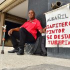 Alejandro Jama muestra un cartel donde detalla los tipos de trabajo que efectúa.