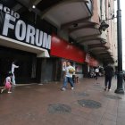 Muchos peatones transitan por la acera frente al edificio, que tiene más de 30 años de antigüedad.