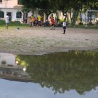 Niños practicando fútbol en la cancha inundada y repleta de mosquitos.