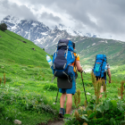 Dos turistas subiendo una montaña como excursionistas, disfrutando del paisaje mientras avanzan.